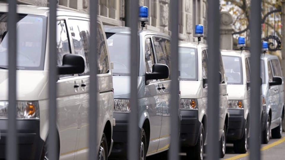 Kastenwagen der Zürcher Stadtpolizei hinter einer Gitterreihe.