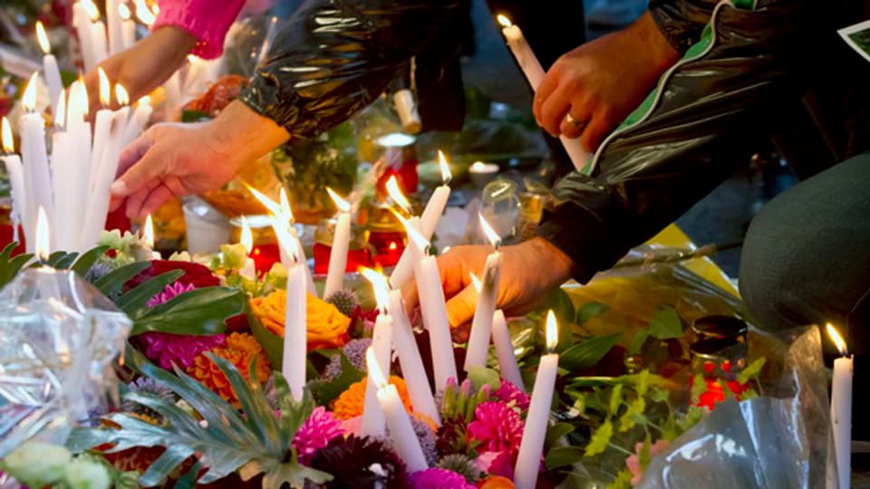 Mit einem Blumenmeer und Kerzen gedachten Hunderte der Tötung vor dem Kaufleuten