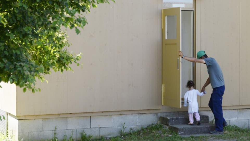 Das beschleunigte Asylverfahren funktioniert. Ein Mann und ein Kind betreten eine Unterkunft im Asylzentrum Juch der Stadt Zürich.