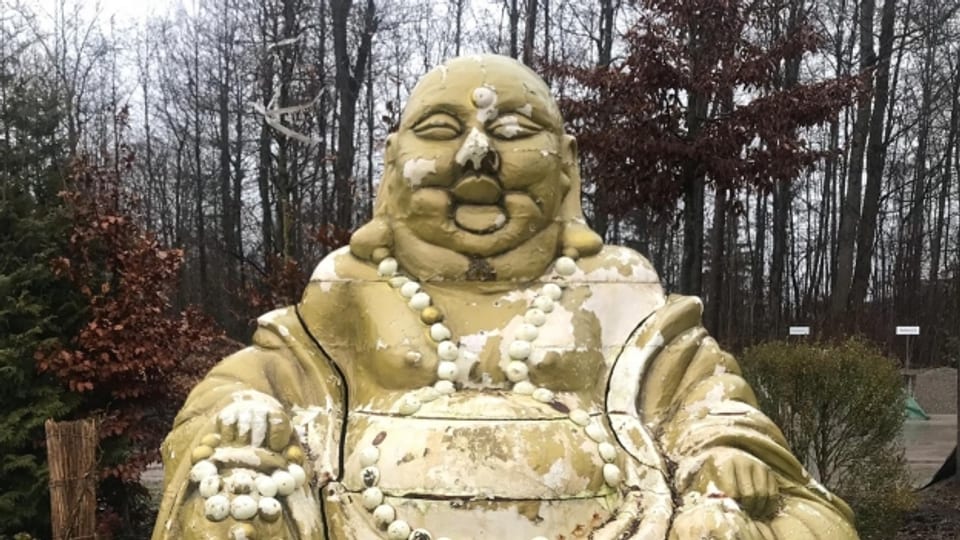 Die Farbe blättert ab an der Buddha-Figur