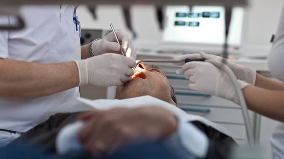 Zahnarzt Martin von Ziegler untersucht in seiner Praxis die Zähne eines Patienten.