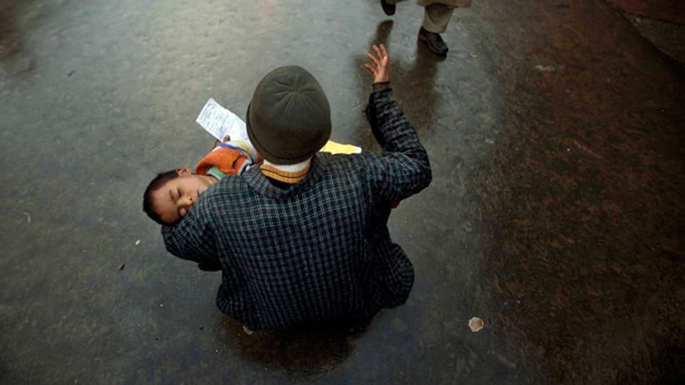 Bettlerin mit Kind in Indien.