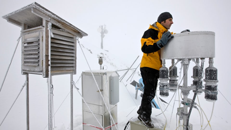 Ein Mitarbeiter des Eidgenössischen Instituts für Schnee- und Lawinenforschung prüft seine Messanlage.