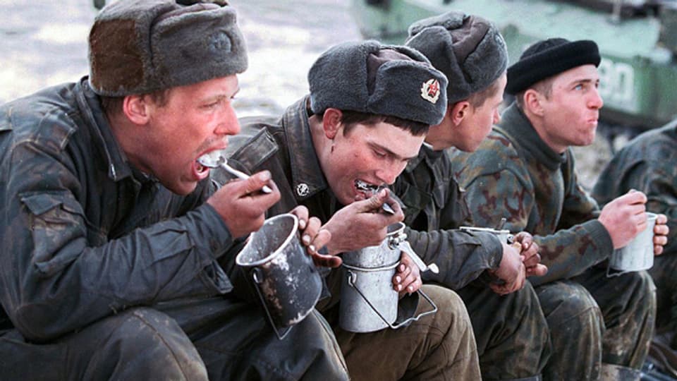 Russische Soldaten machen Mittagsrast und essen aus der Gamelle.