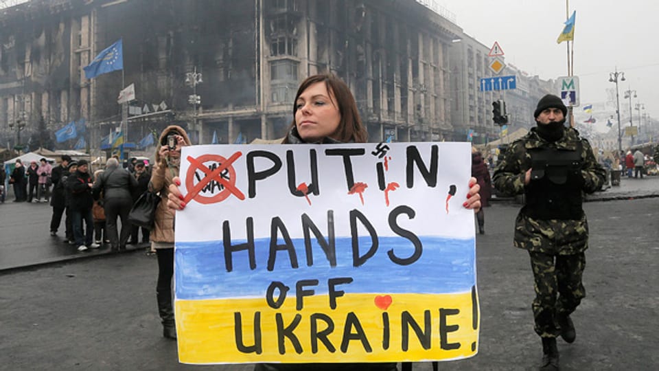 «Putin, Hände weg von der Ukraine» – eine Frau mit einem Plakat im Zentrum Kiews.