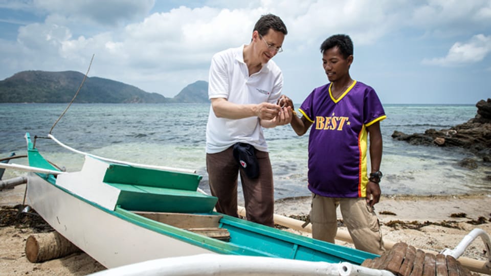 SRK-Direktor Markus Mader lässt sich von einem Fischermann auf der philippinischen Insel Busuanga / Region Palawan die Fischerei-Technik erklären.