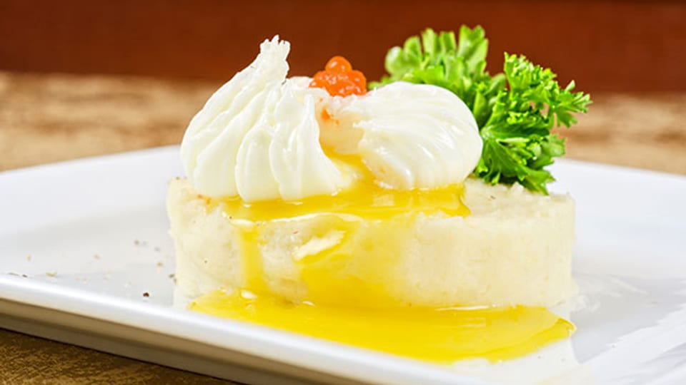 Pochierte Eier in einem Nest aus Kartoffelpüree mit Kaviar.