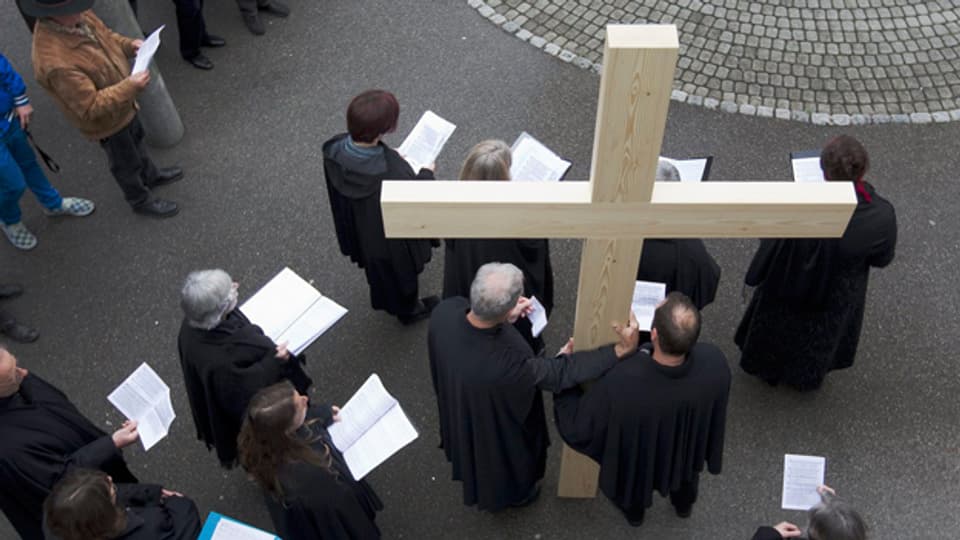 Mitglieder der reformierten Kirchgemeinde Münchenbuchsee singen ein Lied während einer Karfreitagsprozession.