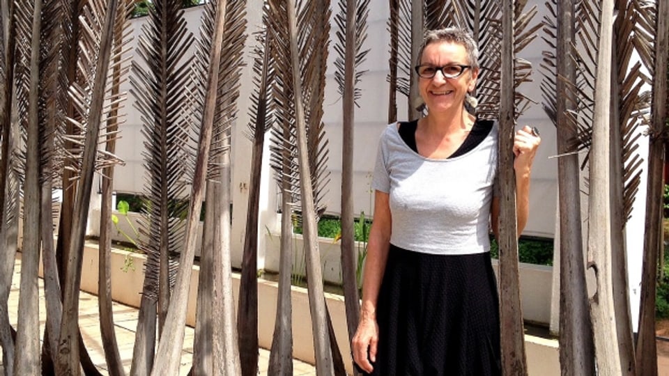 Sonja Weder vor einer selbst gemachten Installation aus Zweigen der Kokospalme