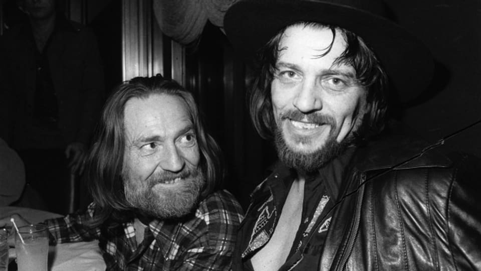 Willie Nelson und Waylon Jennings posieren auf einer schwarzweiss Fotografie.