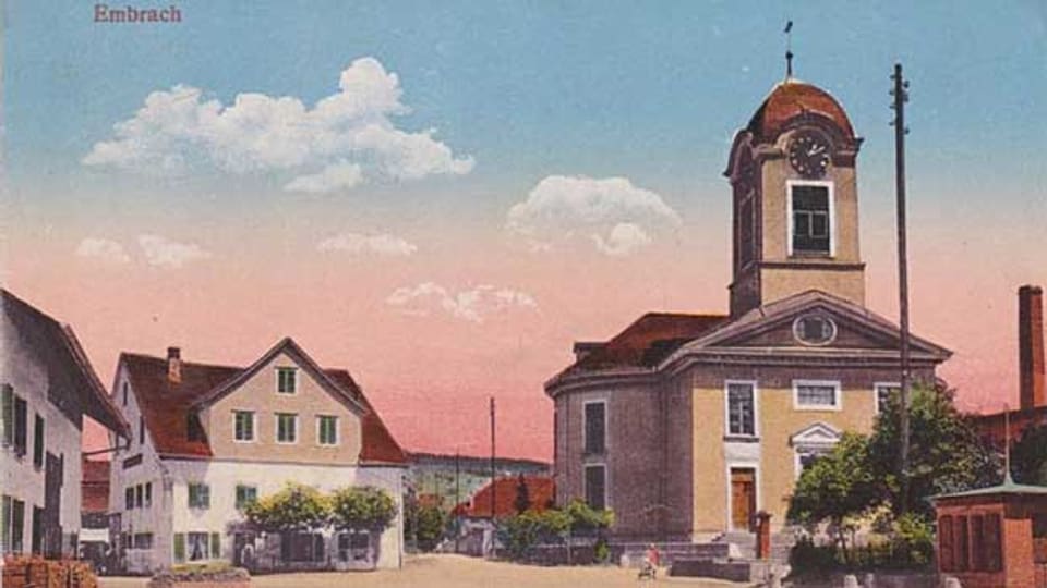 Aufnahme von 1906: Dorfstrasse mit Schulhaus, Kirche, Restaurant Linde, Rechts: Dorfstrasse 5 «Eisenwaren und Werkzeuge»