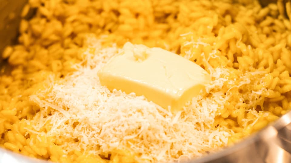 Mit einem Stücken Butter wird der Safran Risotto noch sämiger.