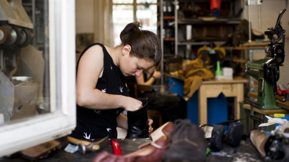 Eine junge Schuhmacherin in Ausbildung