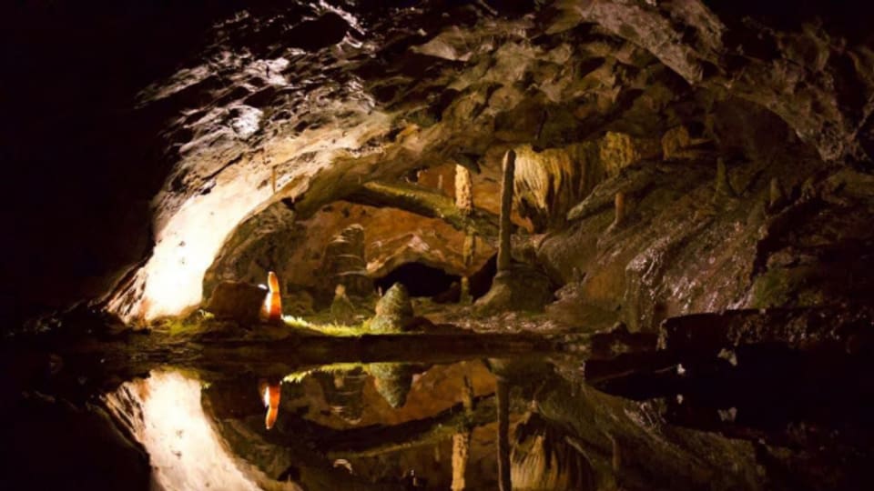 Tropfsteine spiegeln sich in der St. Beatushöhle im Wasser.