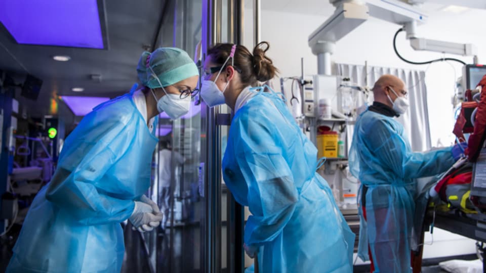 Medizinisches Personal im Universitätsspital Lausanne bereitet einen Covid-19-Patienten für einen Rega-Transport ins Inselspital Bern vor.