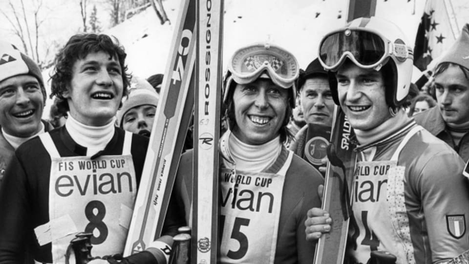 Der Schweizer Roland Collombin gewinnt 1974 die Abfahrt. Der Osterreicher Franz Klammer, links, wird Zweiter, der Italiener Herbert Plank Dritter.
