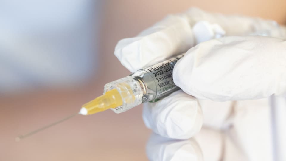 Eine Apothekerin wird gleich den Impfstoff gegen die saisonale Grippe verabreichen.
