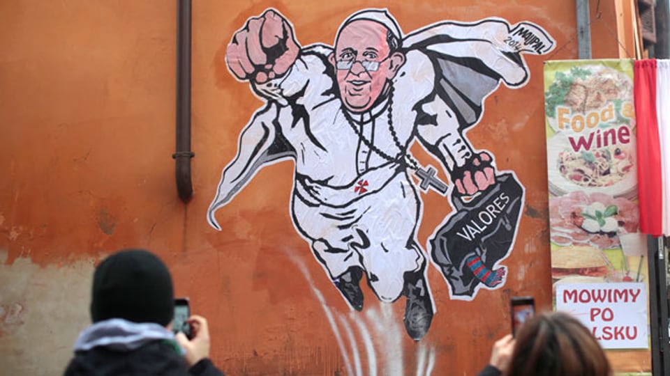 Ein auf einer Hausmauer in Rom angebrachter Wandsticker zeigt Papst Franziskus als Superhelden.