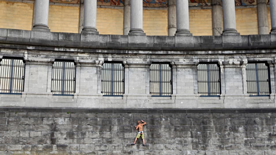 Ein Mann übt sich im Klettern an der Mauer des Cinquantenaire Monuments in Brüssel.