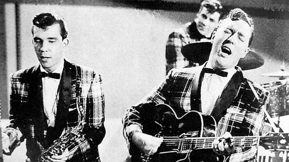 «Rock Around the Clock»-Sänger Bill Haley (r.) während eines Fernsehauftrittes, 1954