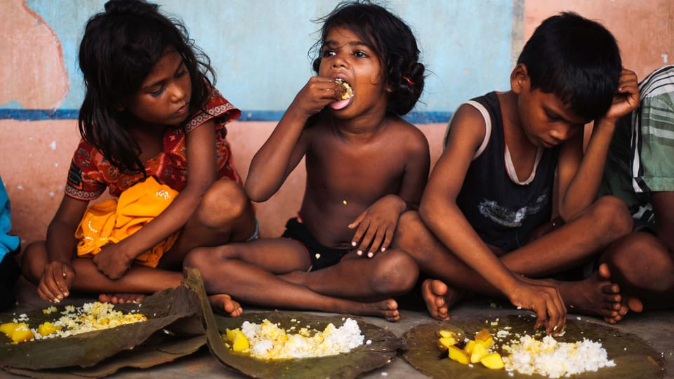 Kinder beim Mittagessen in Odisha/Indien.