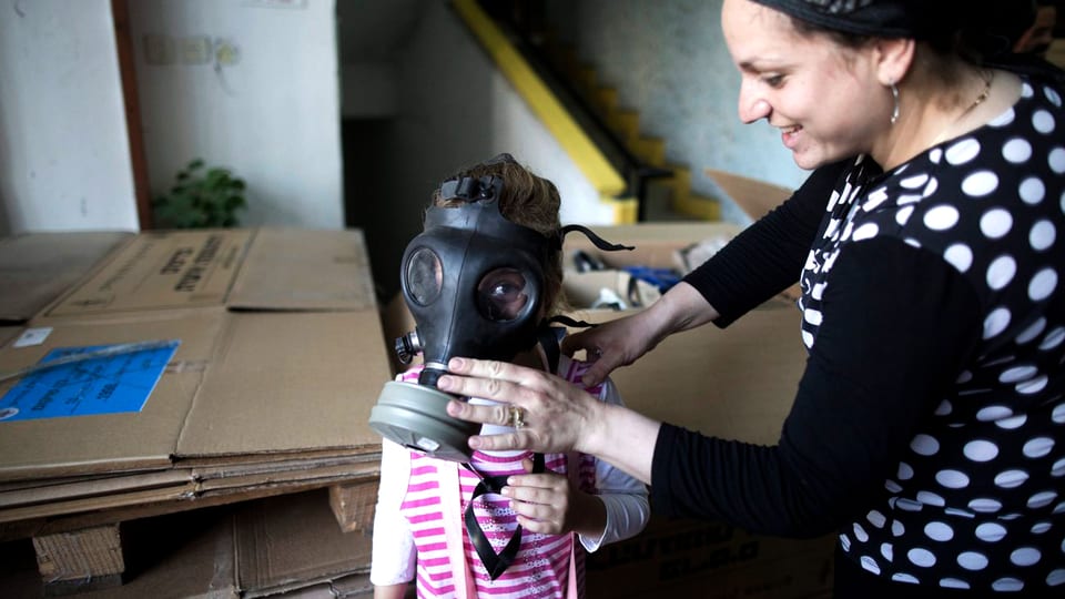 Ein kleines Mädchen in Syrien lernt, wie sie die Gasmaske anziehen muss.
