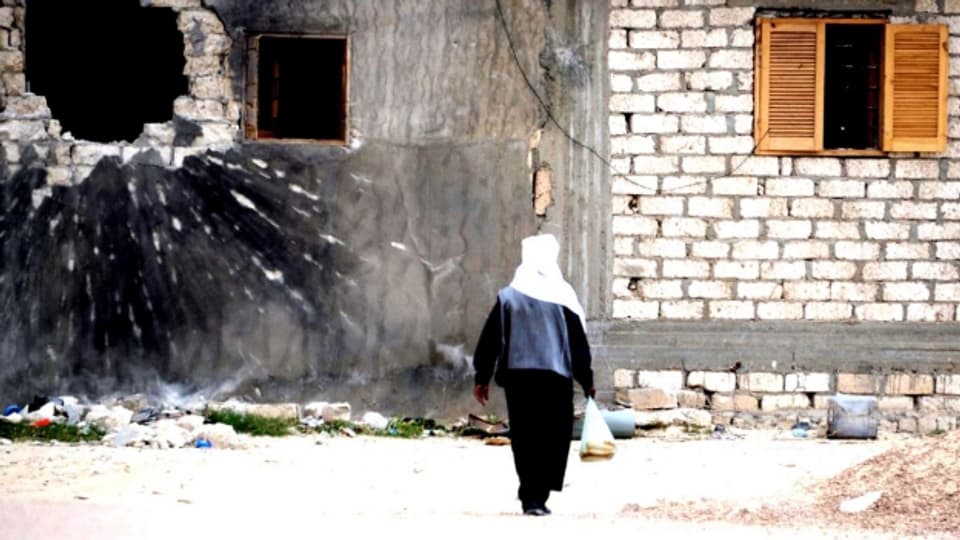 Spuren des Krieges: ein Mann vor einem zerstörten Haus in der libyschen Stadt Adschdabiya
