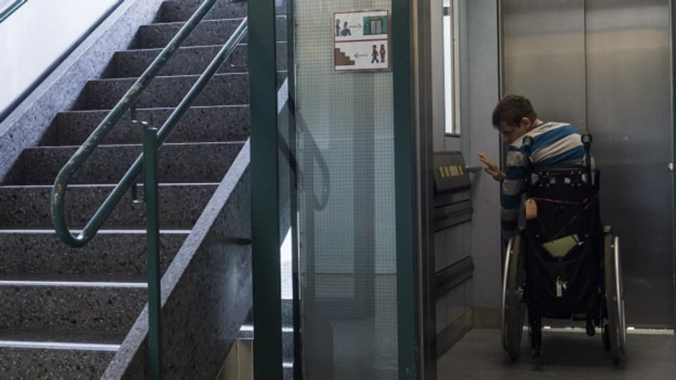 Mann im Rollstuhl fährt Lift in seine Wohnung