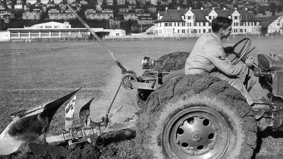 Ein Bauer pflügt während dem zweiten Weltkrieg ein Sportplatz in Zürich.