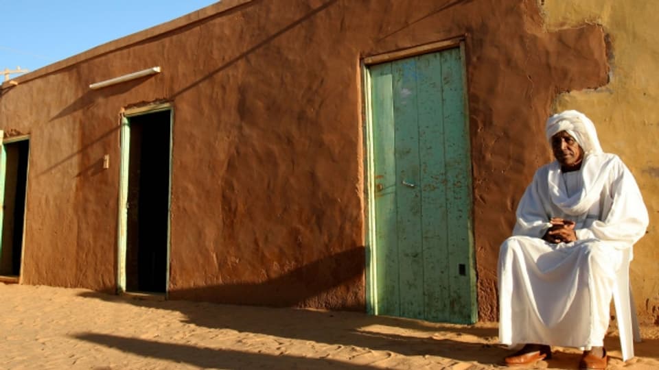 Ein Sudanese sitzt vor seinem Haus