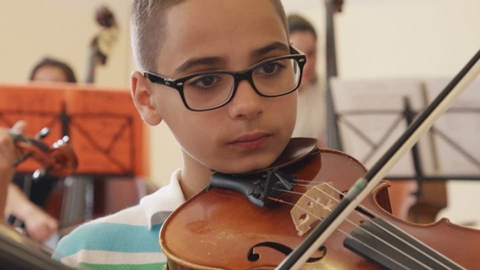 Ein Junge, Mitglied des Superar-Orchesters, spielt Geige