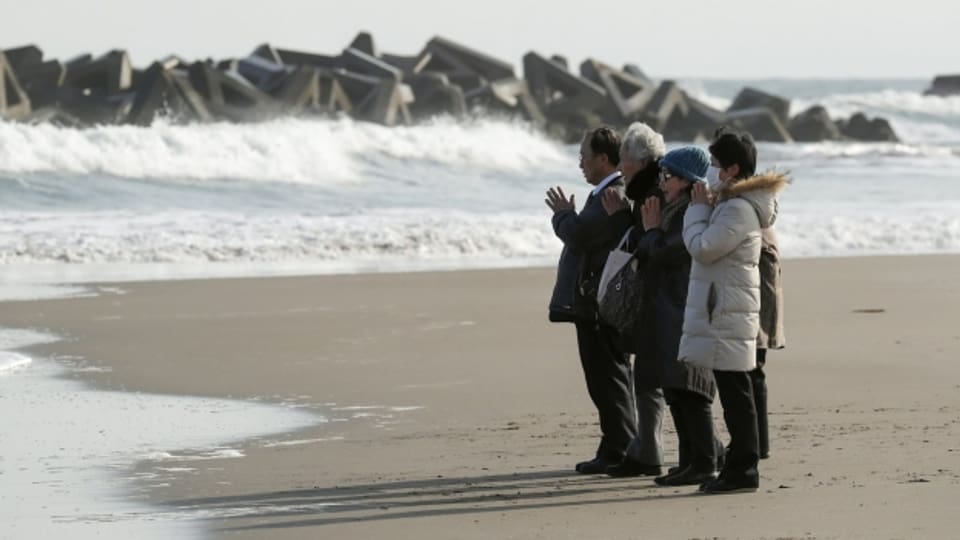 Menschen beim Gedenken an Fukushima.