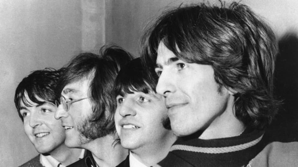 Nahaufnahme von 5 Männern – den Beatles – die nah beieinander stehen.