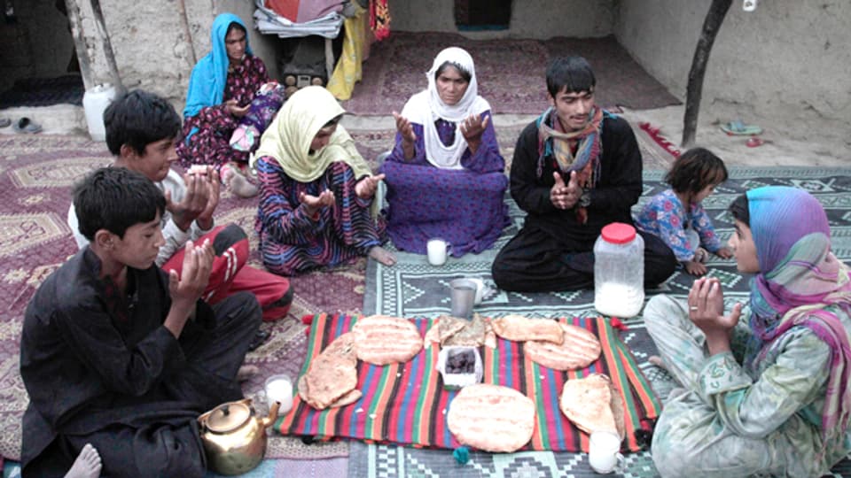 Eine afghanische Familie betet vor dem Fastenbrechen.
