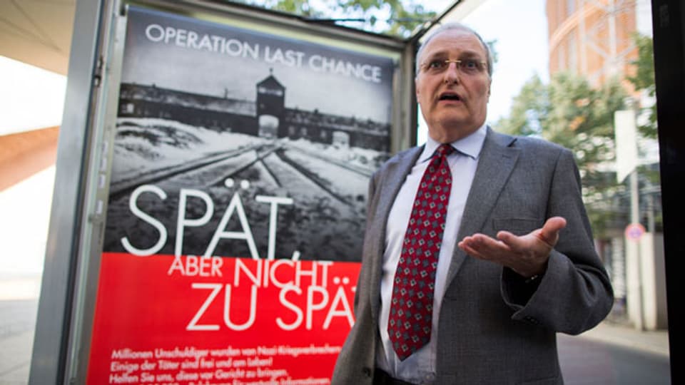 Der Direktor Simon Wiesenthal Centers Efraim Zuroff vor dem umtrittenen Plakat.
