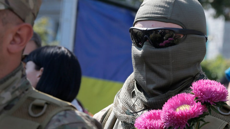 Ein Soldat in Kiev erhält Blumen, bevor er in die Ostukraine zieht.