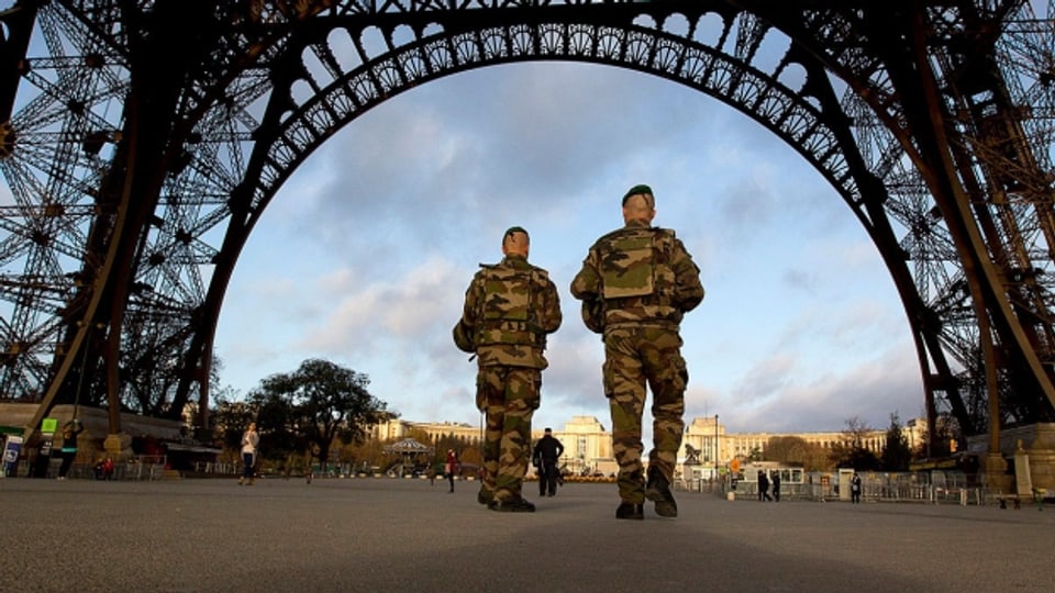 Französische Soldaten patroullieren unter dem Eiffelturm.