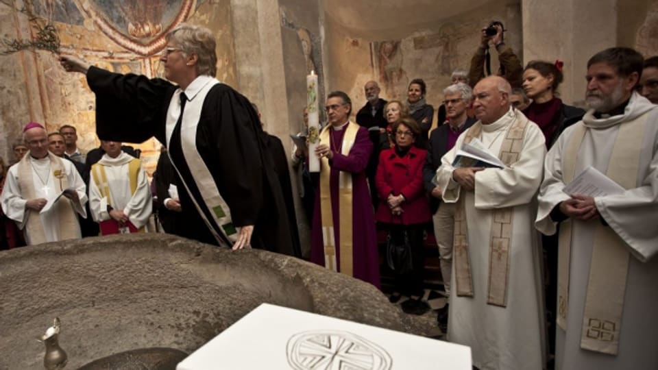 Im Baptisterium in Riva San Vitale wird ein Taufbecken geweiht. Vertreter sechs christlicher Kirchen nehmen teil.