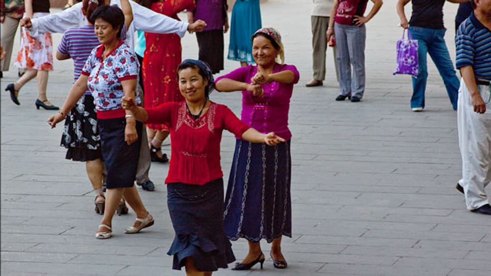 Frauen tanzen in einem öffentlichen Park von Ürümqi.