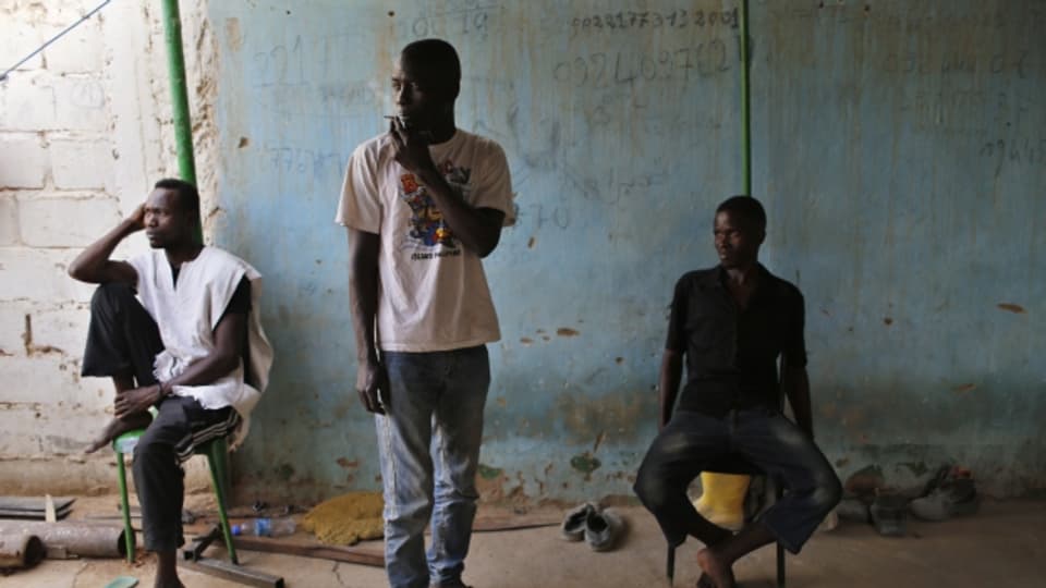 Eine Handynummer als letzte Hoffnung: junge Männer aus Zentralafrika in einer temporären Unterkunft in Libyen.