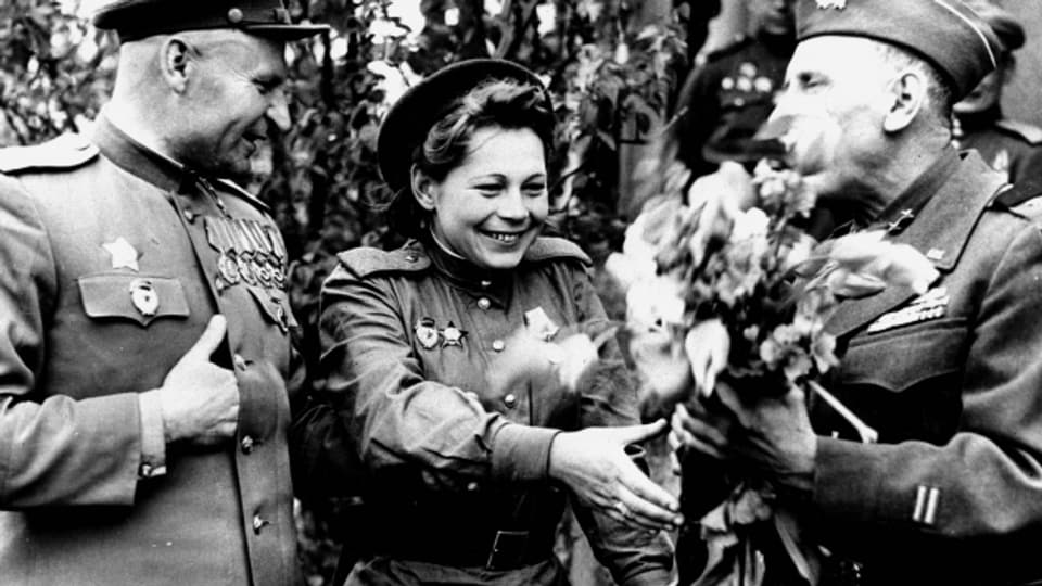 Sowjetische Soldatin bekommt Blumen übereicht.