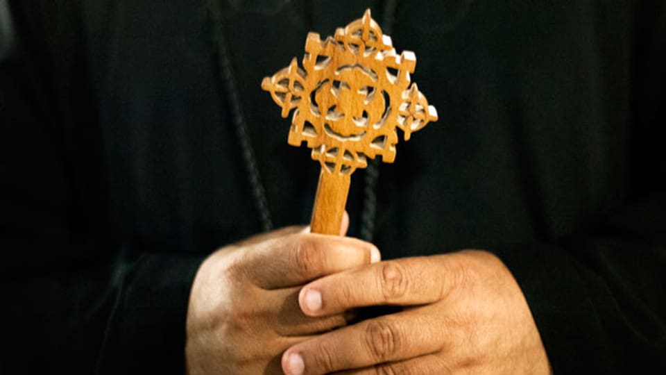 Das koptische Kreuz, in der Hand eines ägyptischen Mönchs.