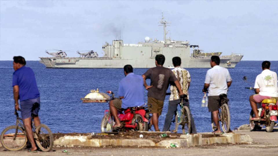 Einwohner der Insel Nauru beobachten den Kreuzer «HMAS Manoora» wie er mit hunderten Flüchtlingen an Bord an der Küste vorbei zieht.