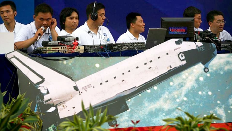 Chinesische Studenten vor dem Modell einer Rakete.