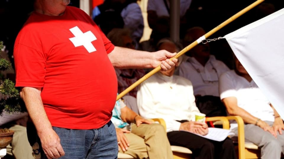 Mann mit Bauch im roten Oberteil mit CH-Flagge drauf.