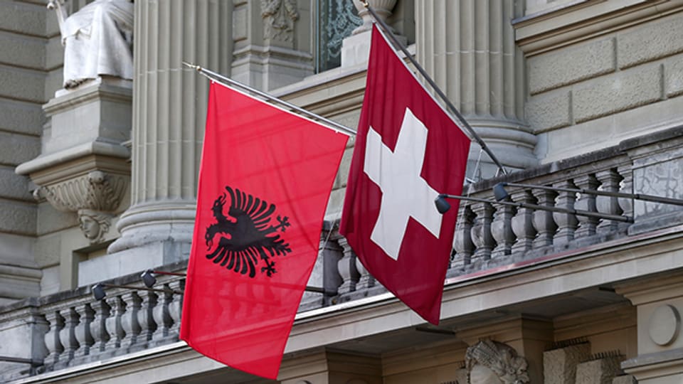 Die Flaggen Albaniens und der Schweiz wehen an der Fassade des Bundeshauses.