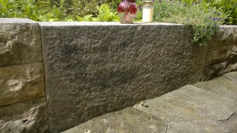 Der Grabstein von Giselas Vater ist in die Gartenmauer des Ex-Freundes einbetoniert.