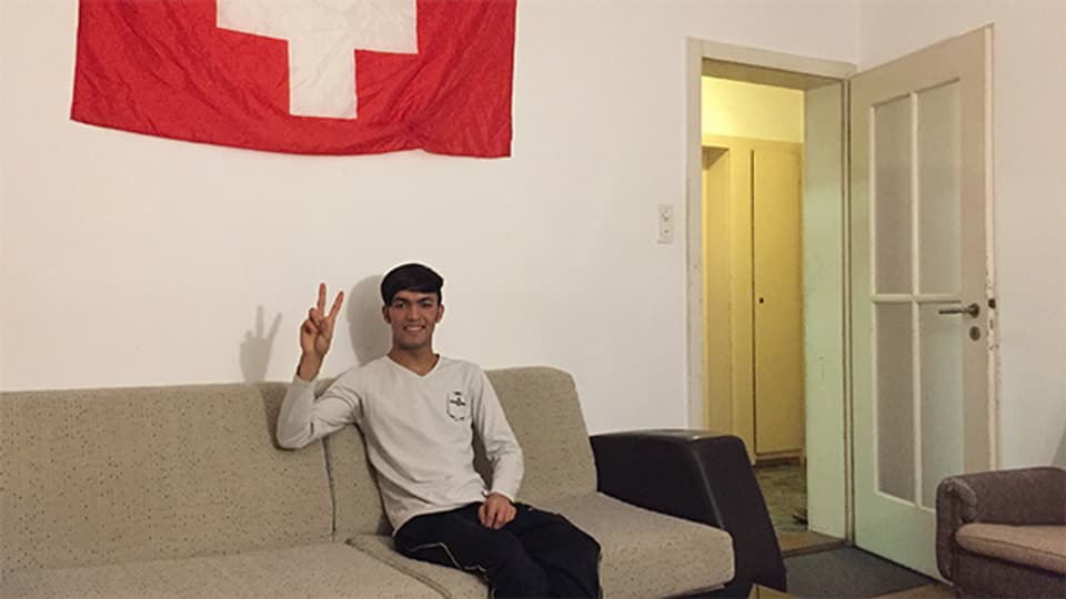 Jawad in seiner 6er WG - die Wohnung ist karg, alt und eng. Als Dank ans Gastgeberland haben sie die Flagge aufgehängt.