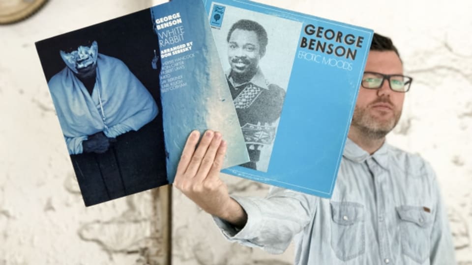 DJ Pesa mit Platten des amerikanischen Jazz-Gitarristen George Benson.