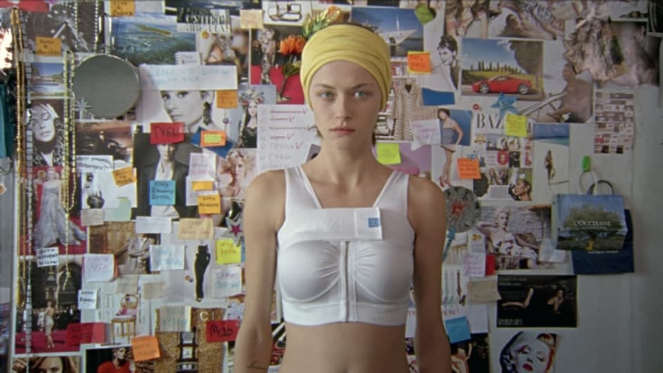 Mascha (Tina Dalakischwili) nach der Brustvergrösserung vor ihrer Idolwand.